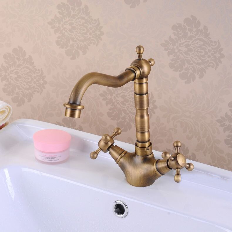 Antique brass bathroom sink faucet with 360-degree swivel spout and dual cross handles, showcasing elegant design and functionality.