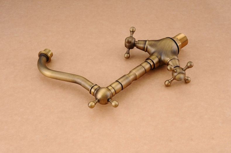 Antique brass bathroom sink faucet with 360-degree swivel spout and dual cross handles, showcasing elegant design and functionality.