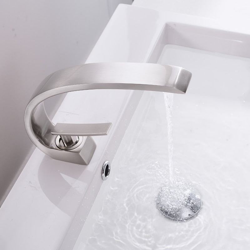 Modern brass basin faucet with single handle and sleek design, available in chrome, brushed nickel, and black finishes.