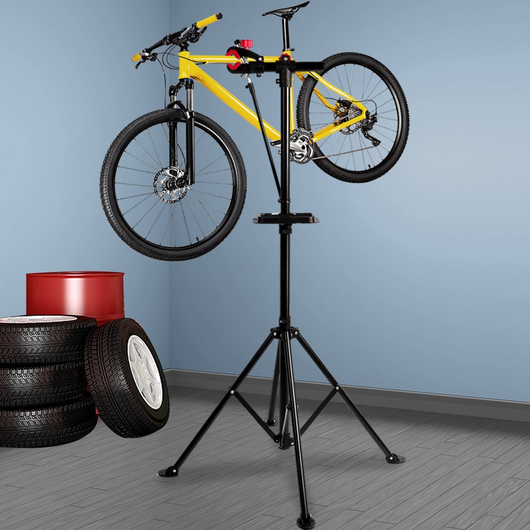 Ergonomic bike repair stand with tool tray, featuring a 360° swivel clamp and a sturdy four-legged base, ideal for home mechanics.