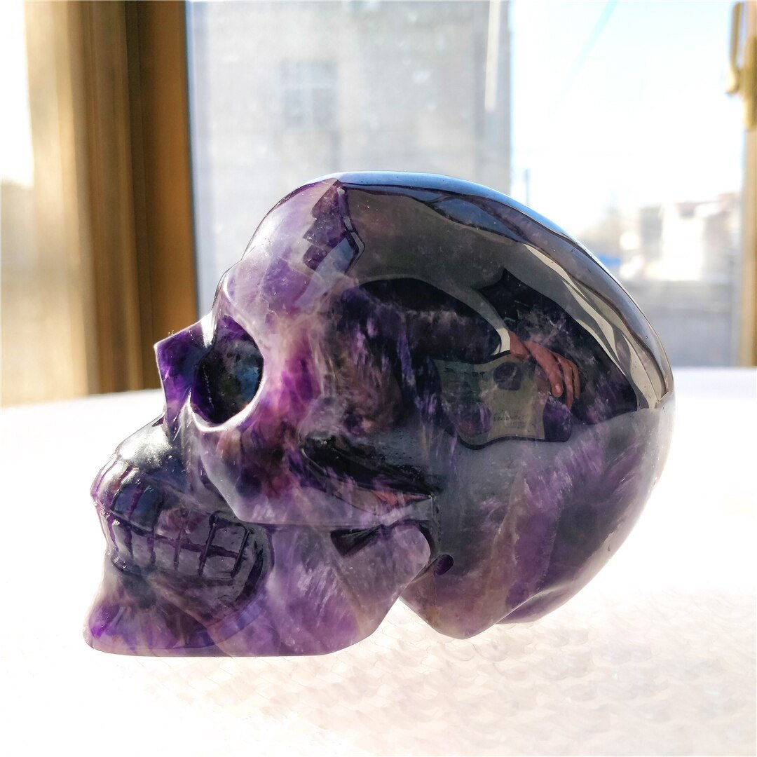 A beautifully hand-carved Brazilian Dream Amethyst skull with a polished finish, showcasing intricate details and rich purple hues.