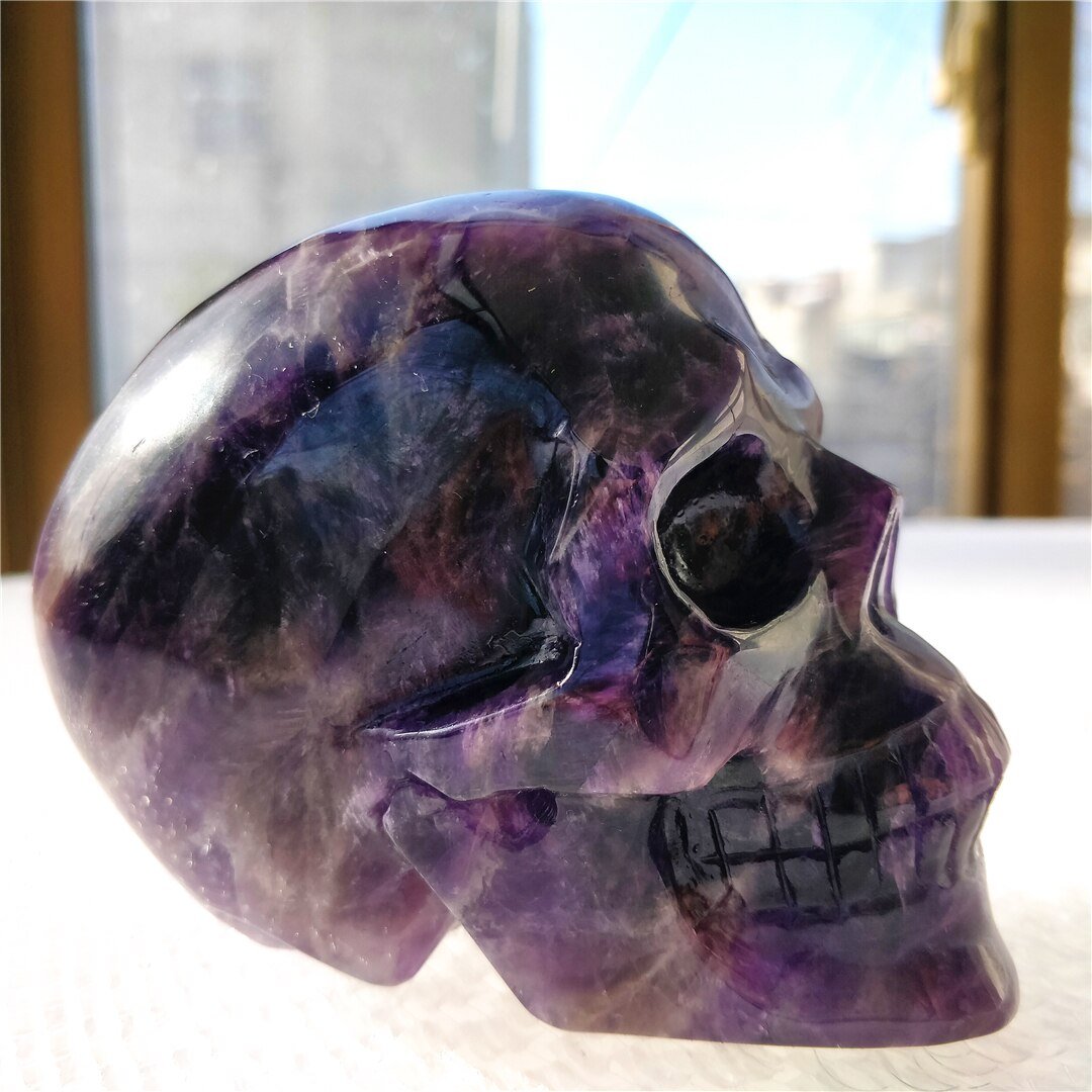 A beautifully hand-carved Brazilian Dream Amethyst skull with a polished finish, showcasing intricate details and rich purple hues.