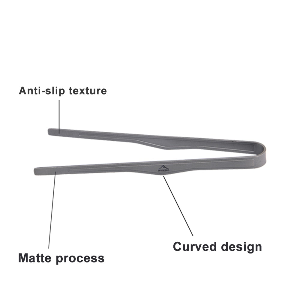 A lightweight titanium tea cup clip designed for outdoor use, featuring a kidney shape for easy handling and versatility during camping and barbecues.