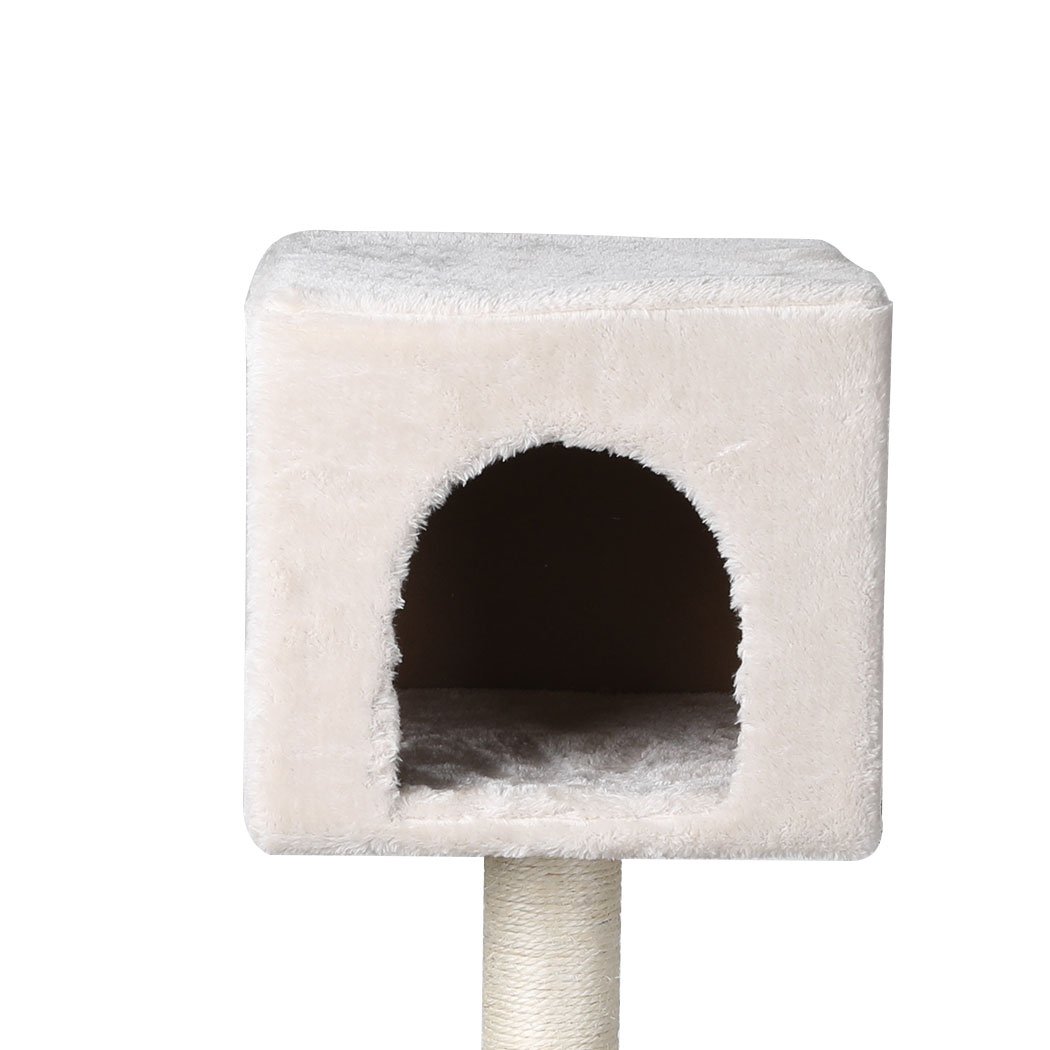 A beige multi-level cat tree tower with plush covering, sisal scratching posts, and hanging toys, designed for playful cats.