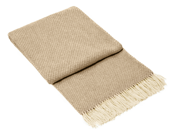 Chiswick Throw Blanket in beige, made from luxurious merino wool and cashmere, elegantly draped on a cozy sofa.