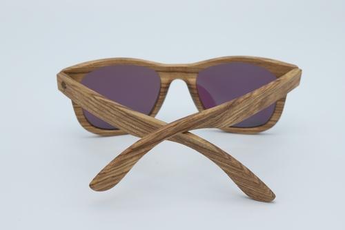 Classic sunglasses with zebra wood frames and polarized green lenses, displayed in a stylish wood box with microfiber accessories.