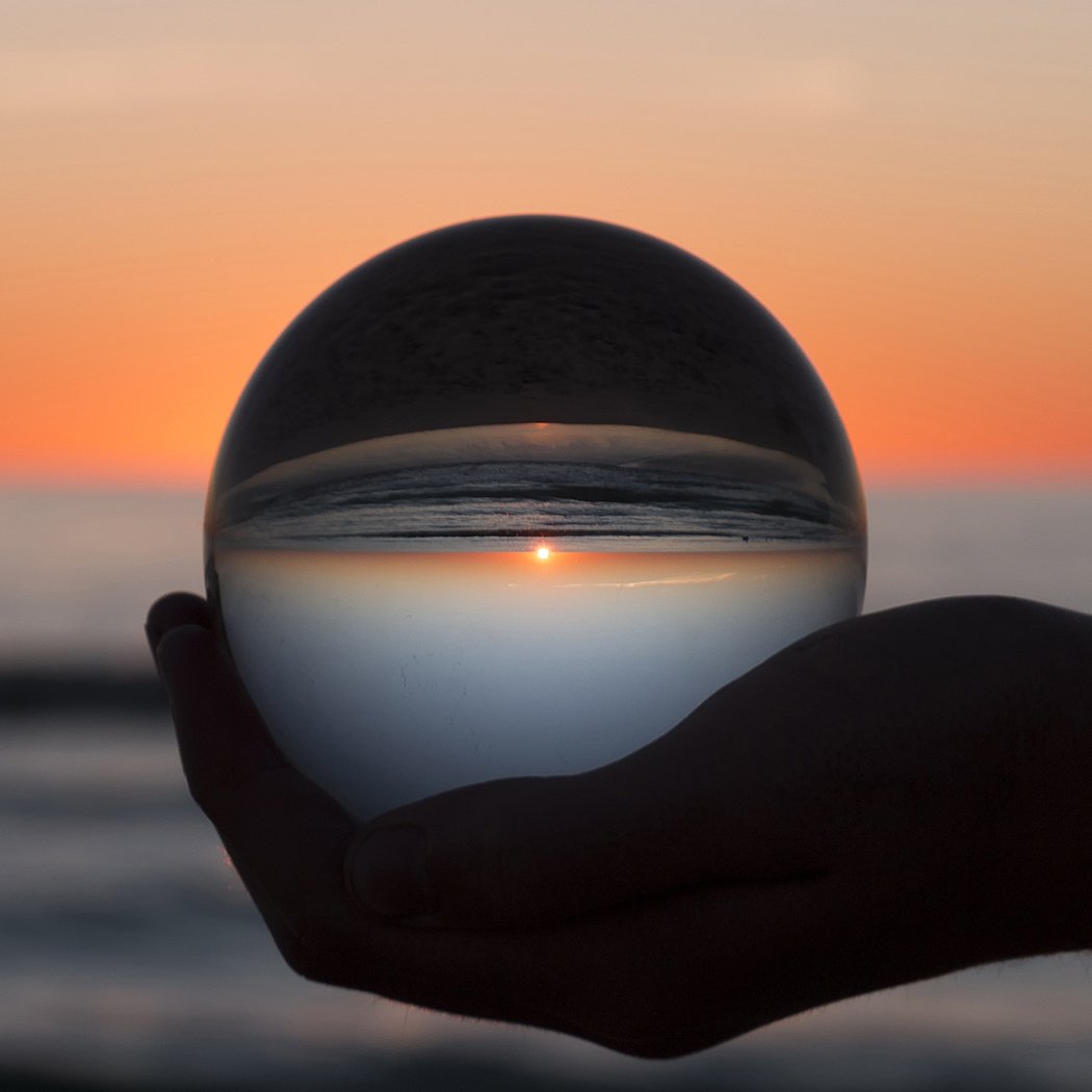 A clear glass healing crystal ball sphere, perfect for photography and home decor, displayed on a wooden surface with soft lighting.