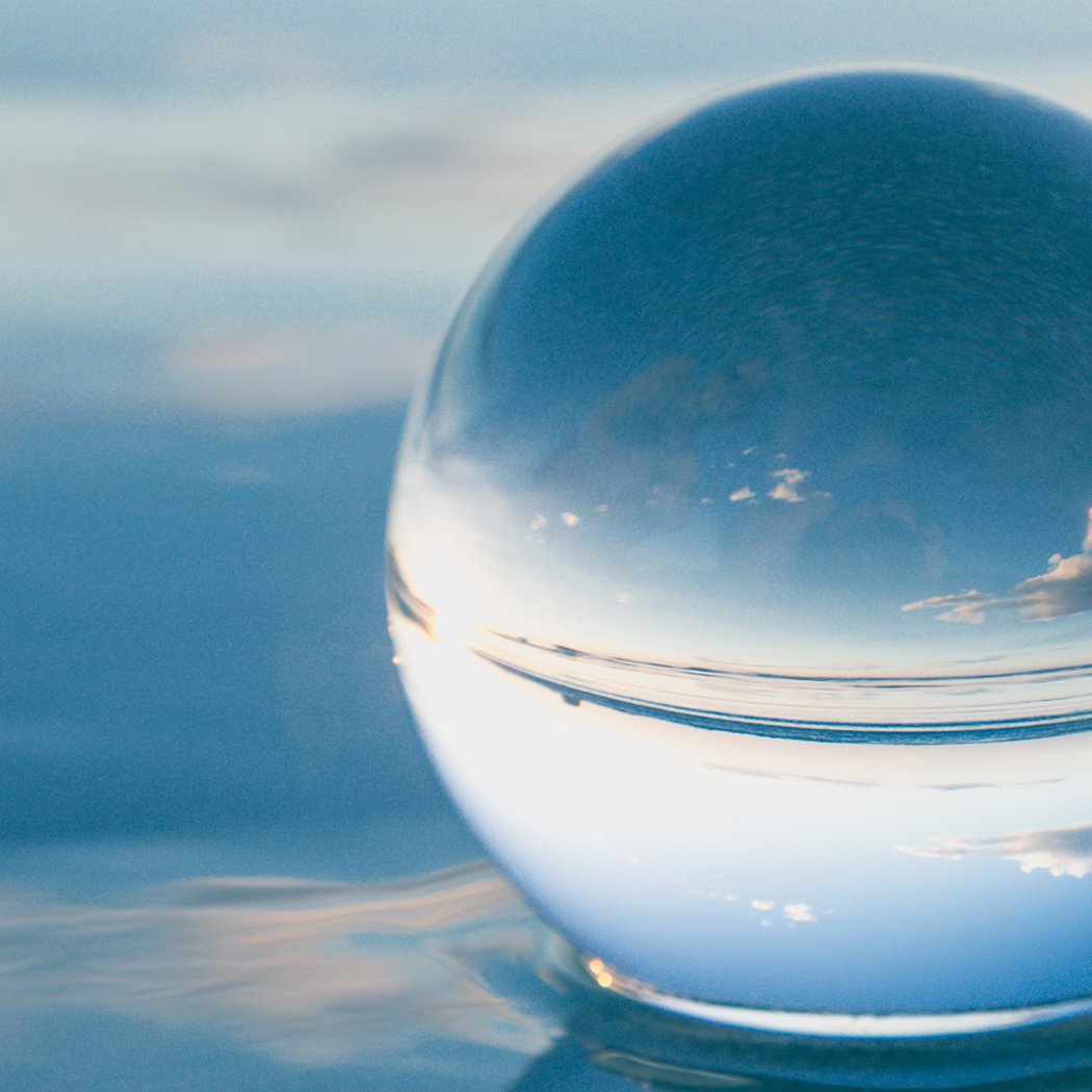 A clear glass healing crystal ball sphere, perfect for photography and home decor, displayed on a wooden surface with soft lighting.