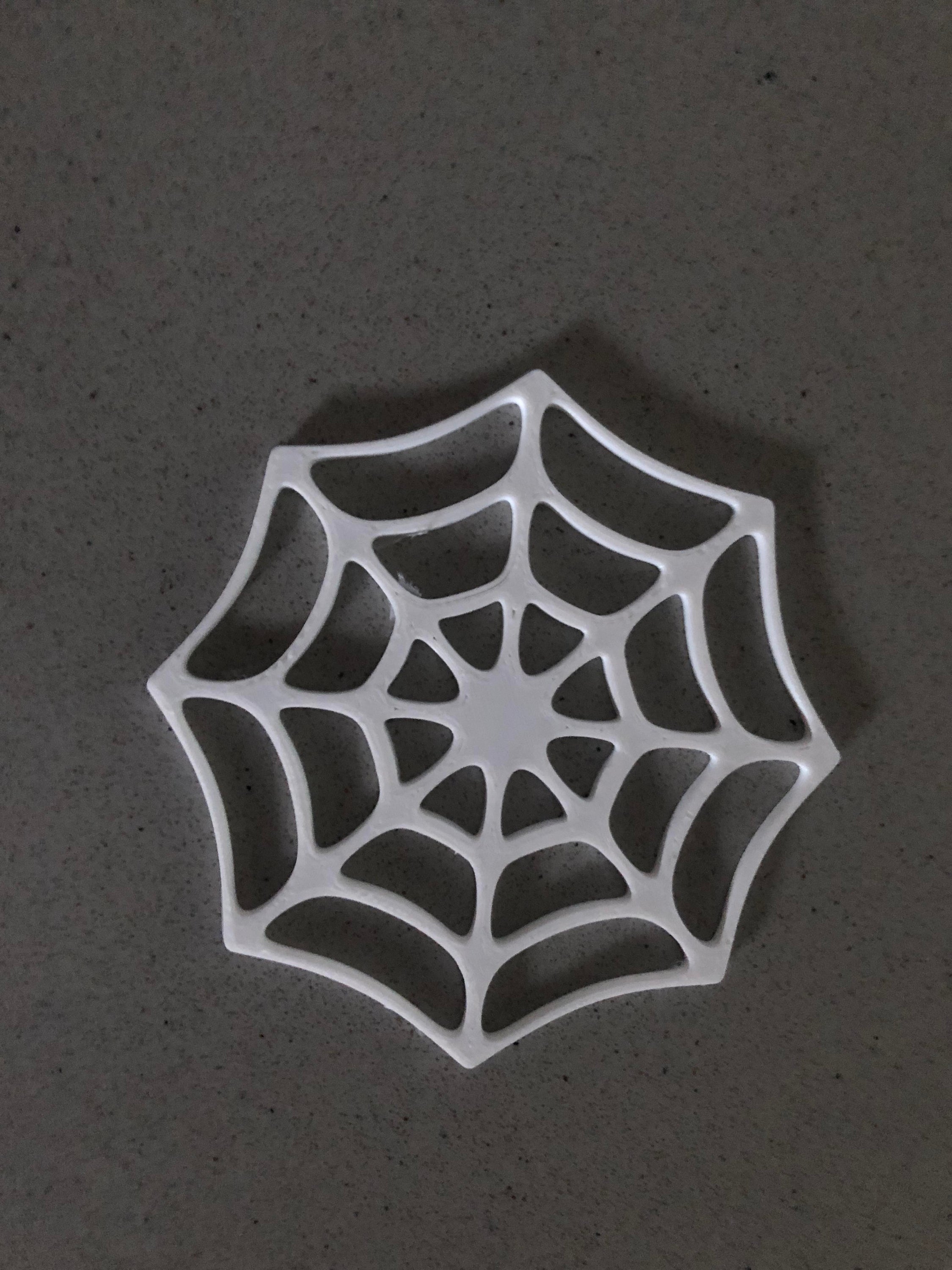 A set of four Halloween-themed coasters featuring intricate cobweb designs in black and white colors, perfect for holding cups and mugs.