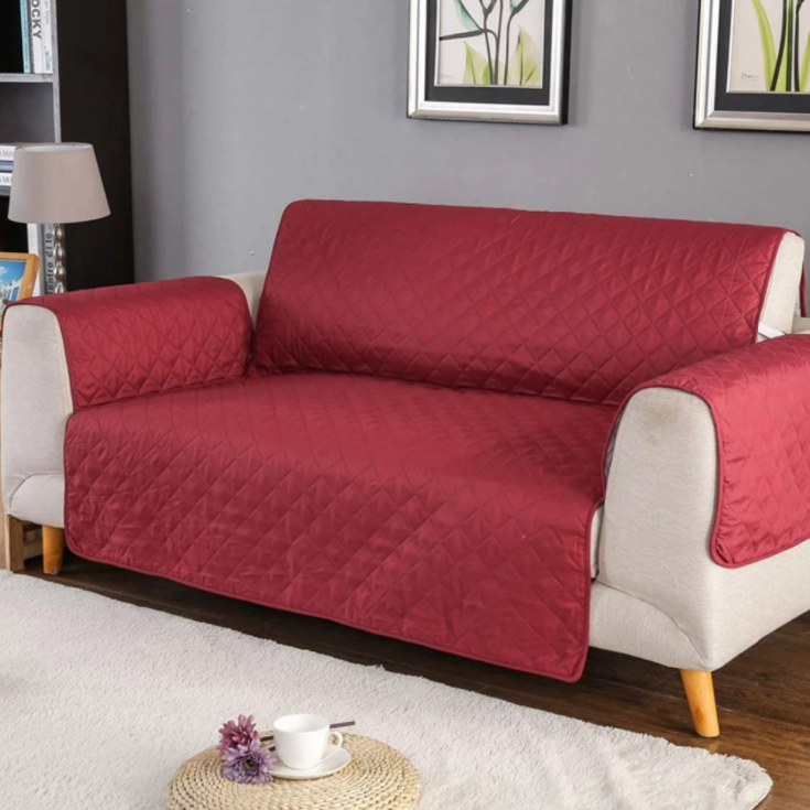 Reversible black and red couch cover protector for 2-seater sofas, featuring a quilted design and anti-slip backing.