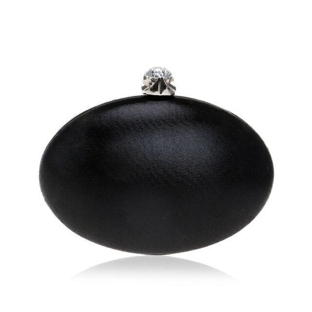 Elegant egg-shaped clutch for women adorned with rhinestones and a chain shoulder strap, perfect for evening events.