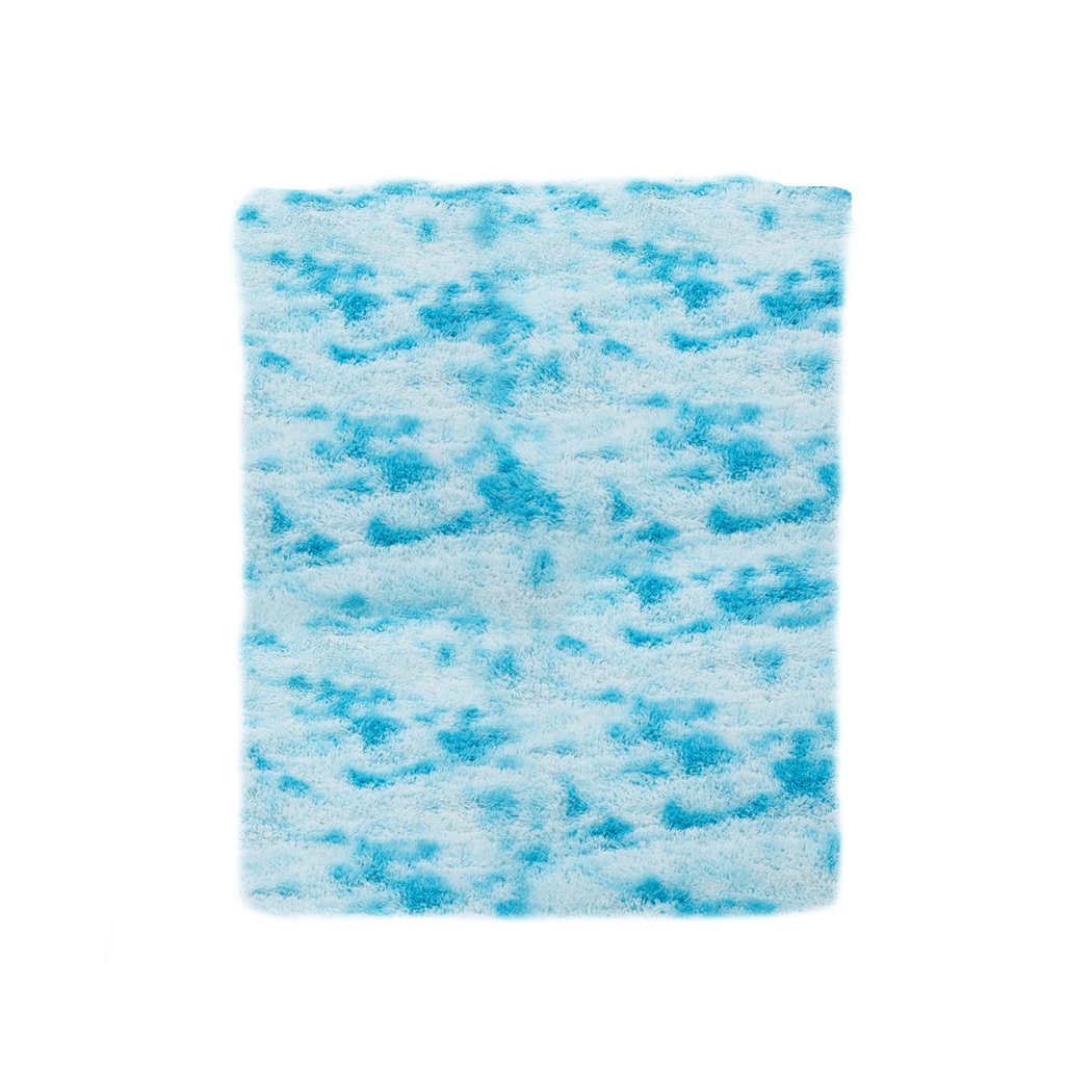 A large, soft shaggy floor rug with a vibrant tie-dyed pattern, showcasing its plush texture and anti-slip silicone bottom.