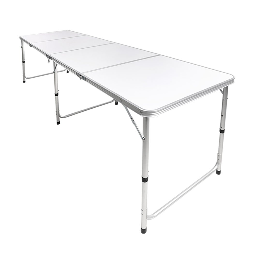 A lightweight and portable folding camping table set up outdoors, showcasing its sturdy aluminum frame and smooth MDF tabletop.