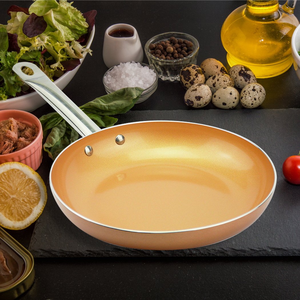 A sleek non-stick stainless steel frying pan with a copper-infused surface, ideal for healthy cooking.