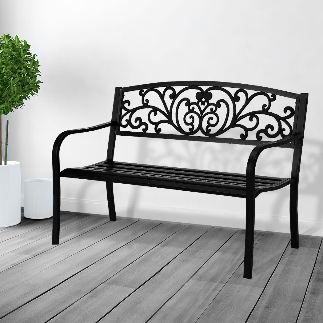 A stylish black garden bench made of galvanized steel and cast iron, featuring a floral backrest and smooth armrests, perfect for outdoor relaxation.