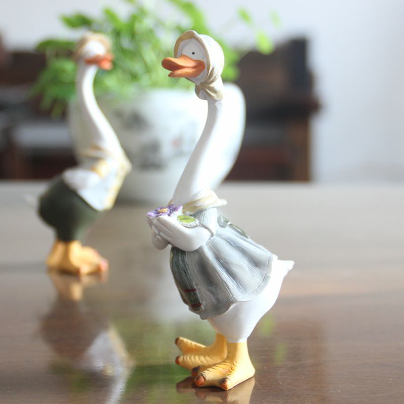 A charming resin duck family figurine set, perfect for garden decoration, showcasing intricate details and vibrant colors.