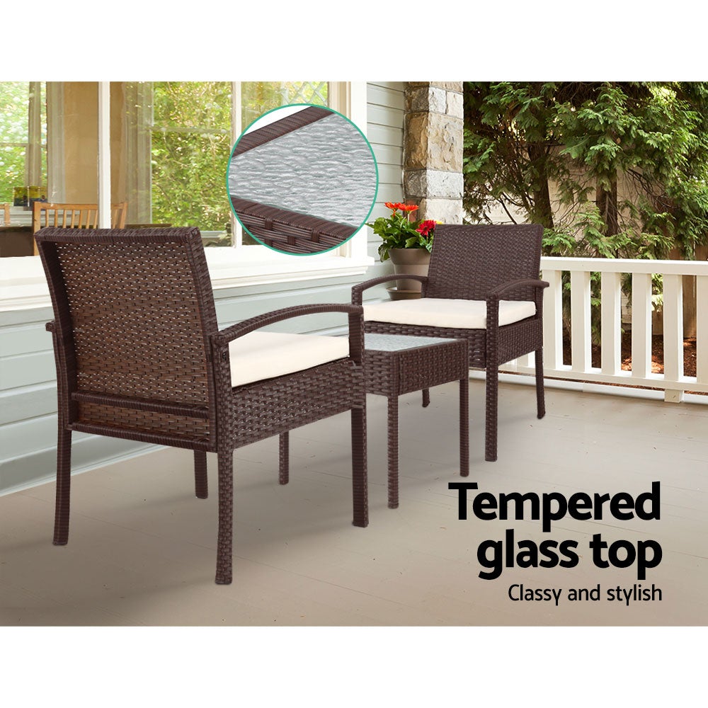 Gardeon 3-piece Outdoor Set featuring brown PE wicker chairs and a side table with a clear tempered glass top, complemented by beige cushions.