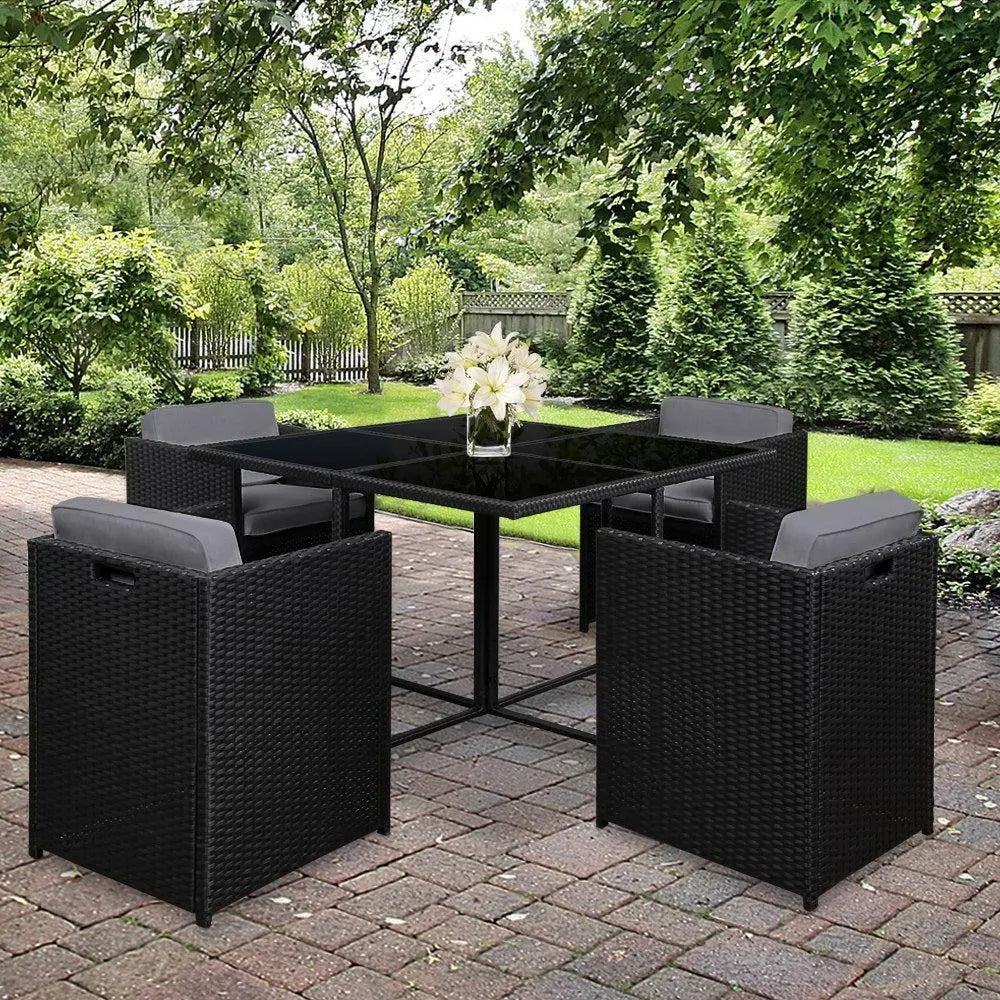 Gardeon 5 Piece Wicker Outdoor Dining Set in Black with grey cushions, featuring a rectangular glass top table and four chairs.