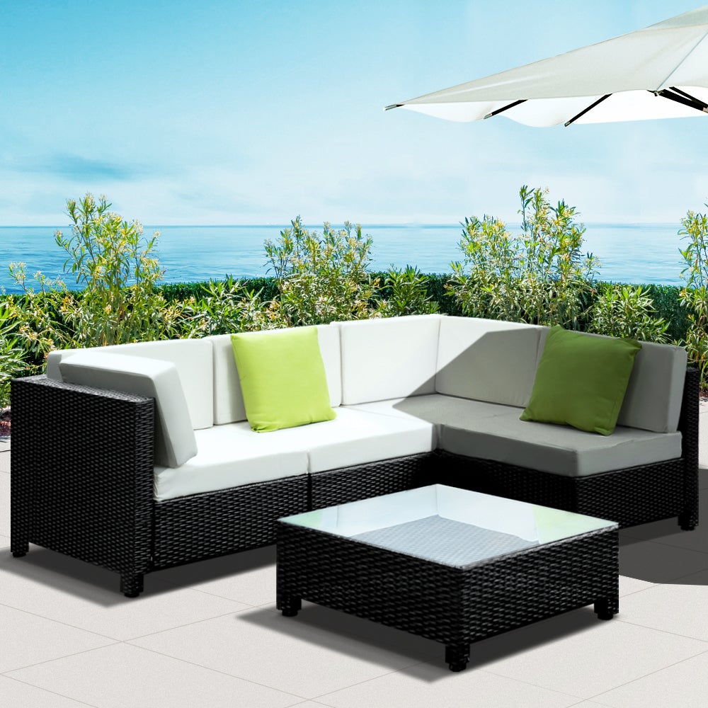 Gardeon 5PC Outdoor Furniture Sofa Set featuring modular wicker couches, a coffee table with tempered glass top, and vibrant cushions in a backyard setting.