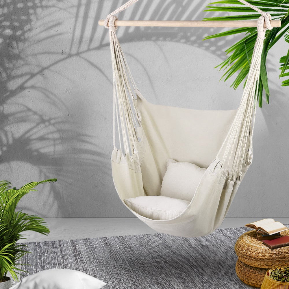 Gardeon Hammock Swing Chair in Cream color with matching cushions, hanging from a sturdy timber rail.