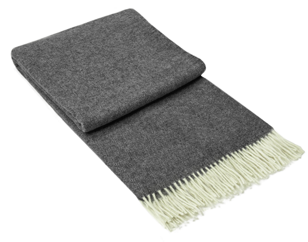 Hampton Throw blanket in dark grey, made from a luxurious Merino wool blend, elegantly draped over a cozy sofa.