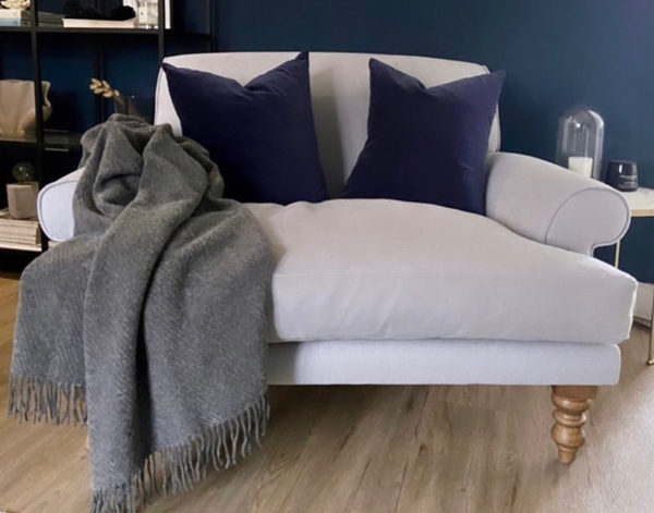 Hampton Throw blanket in slate color, made from Merino wool blend, elegantly draped on a cozy sofa.