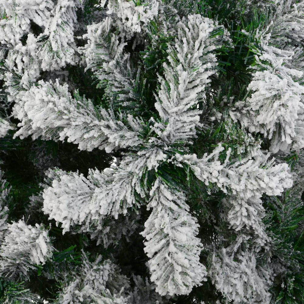 Jingle Jollys 2.1M Christmas Tree with snow-sprayed tips, standing tall in a festive living room setting, adorned with colorful ornaments.