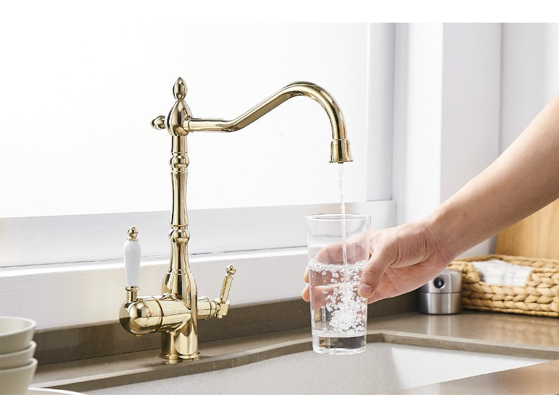 Gold mixer tap with 360-degree rotation and dual handles for hot and cold water, featuring water purification for kitchen use.