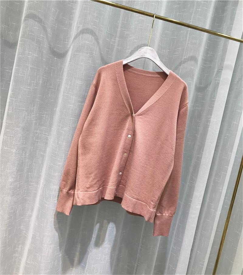 A cozy oversized knitted cardigan sweater in solid color, featuring a V-neck collar and button closure, perfect for spring and autumn wear.