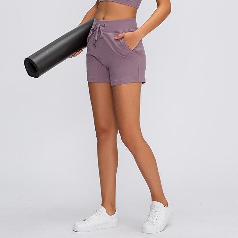 Women wearing Leisure Nylon Yoga Gym Workout Shorts, showcasing high waist design and anti-sweat fabric in a fitness setting.