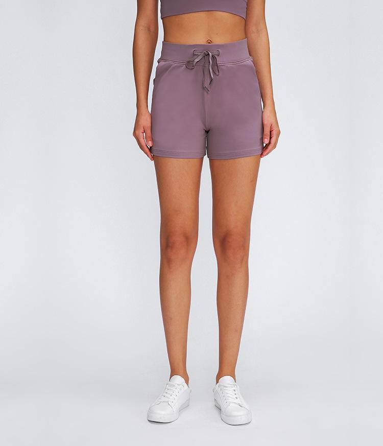 Women wearing Leisure Nylon Yoga Gym Workout Shorts, showcasing high waist design and anti-sweat fabric in a fitness setting.