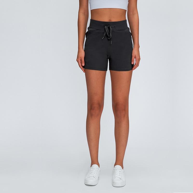 Women wearing Leisure Nylon Yoga Gym Workout Shorts, showcasing high waist design and anti-sweat fabric in a fitness setting.