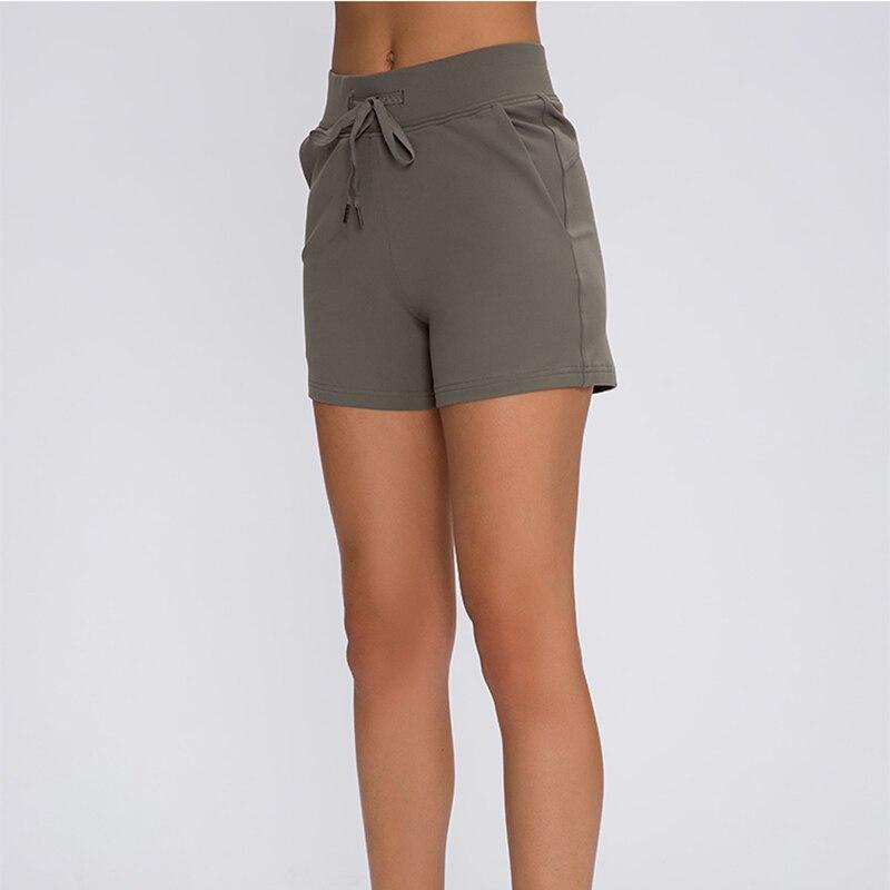 Women wearing Leisure Nylon Yoga Gym Workout Shorts, showcasing high waist design and anti-sweat fabric in a fitness setting.