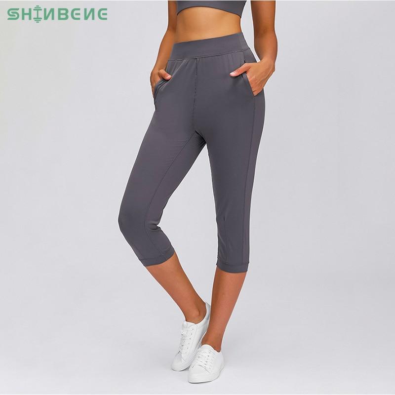 Women wearing high waist yoga capri joggers, showcasing stretchy fabric and side pocket.