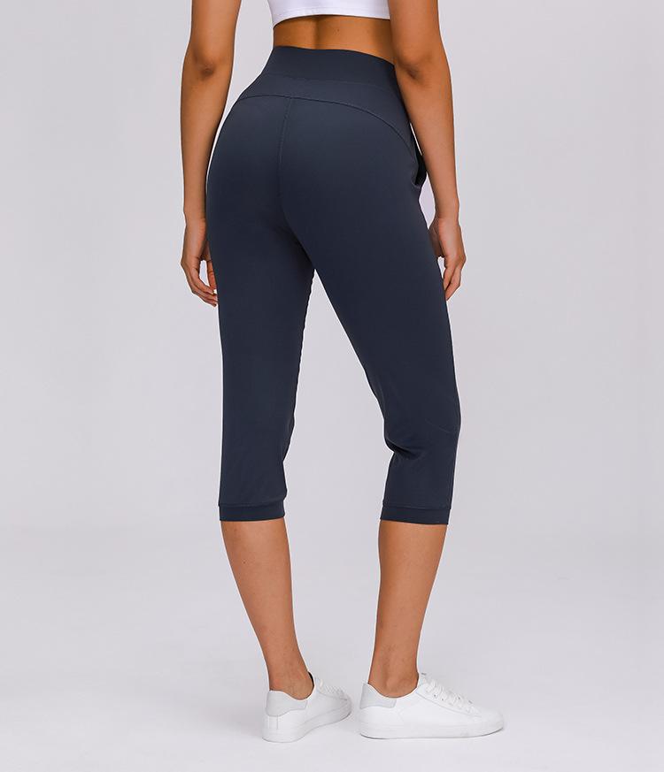 Women wearing high waist yoga capri joggers, showcasing stretchy fabric and side pocket.