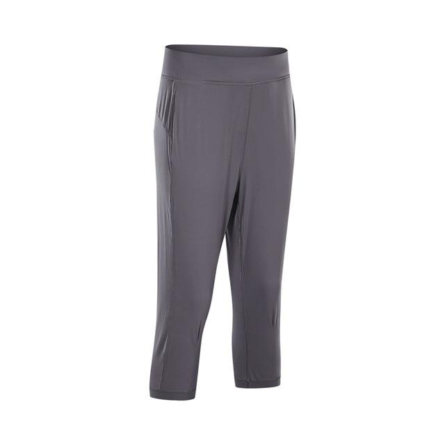 Women wearing high waist yoga capri joggers, showcasing stretchy fabric and side pocket.