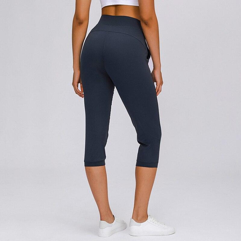 Women wearing high waist yoga capri joggers, showcasing stretchy fabric and side pocket.