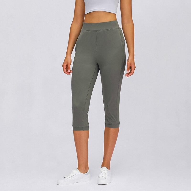 Women wearing high waist yoga capri joggers, showcasing stretchy fabric and side pocket.