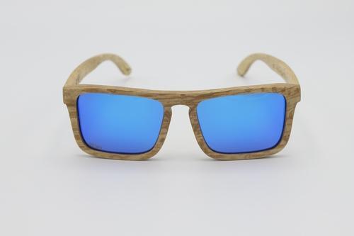 Lizards wood sunglasses featuring grey polarized lenses and black wood frames, presented in an eco-friendly wooden box with accessories.