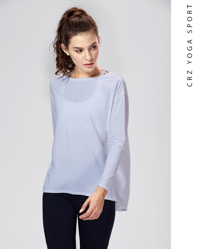 A woman wearing a loose fit long sleeve workout shirt made of Pima cotton, perfect for yoga and casual outings.