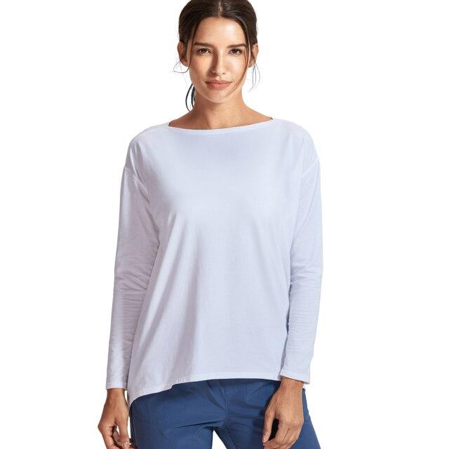 A woman wearing a loose fit long sleeve workout shirt made of Pima cotton, perfect for yoga and casual outings.