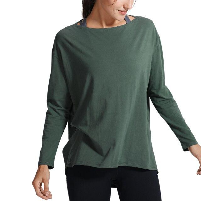 A woman wearing a loose fit long sleeve workout shirt made of Pima cotton, perfect for yoga and casual outings.