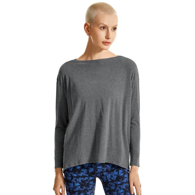 A woman wearing a loose fit long sleeve workout shirt made of Pima cotton, perfect for yoga and casual outings.