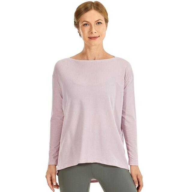 A woman wearing a loose fit long sleeve workout shirt made of Pima cotton, perfect for yoga and casual outings.