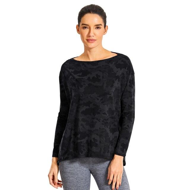 A woman wearing a loose fit long sleeve workout shirt made of Pima cotton, perfect for yoga and casual outings.