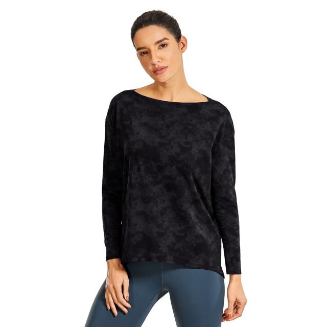 A woman wearing a loose fit long sleeve workout shirt made of Pima cotton, perfect for yoga and casual outings.