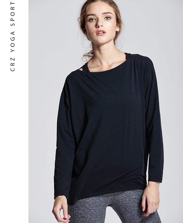 A woman wearing a loose fit long sleeve workout shirt made of Pima cotton, perfect for yoga and casual outings.