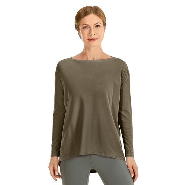 A woman wearing a loose fit long sleeve workout shirt made of Pima cotton, perfect for yoga and casual outings.