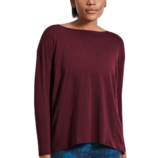 A woman wearing a loose fit long sleeve workout shirt made of Pima cotton, perfect for yoga and casual outings.