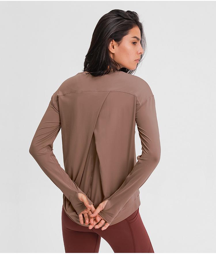 A lightweight long sleeve workout shirt for women, featuring a loose fit and thumb holes, ideal for yoga and fitness activities.